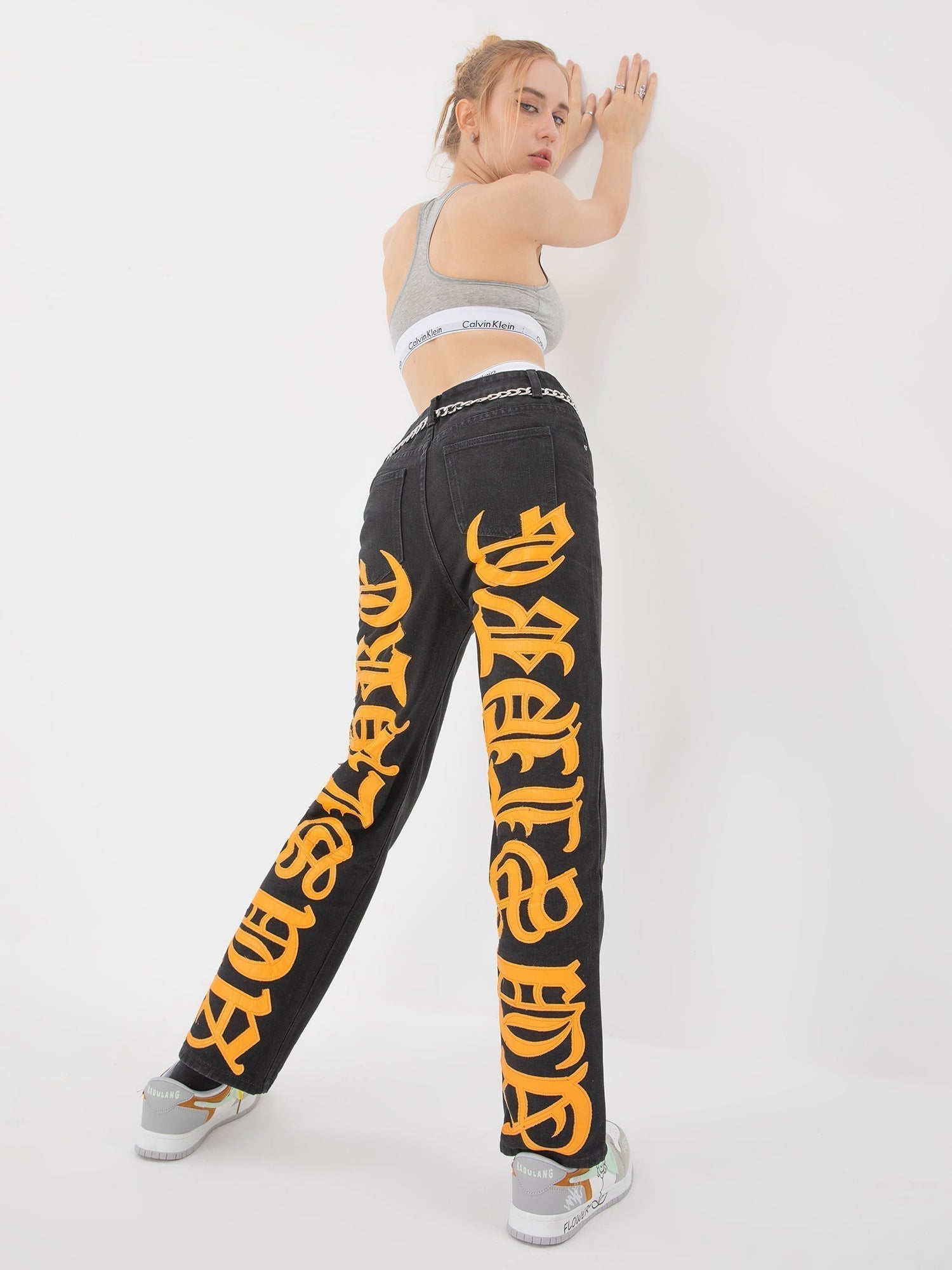 BLACK JEANS WITH ORANGE GOTHIC LETTERING FASHION STATEMENT APPAREL