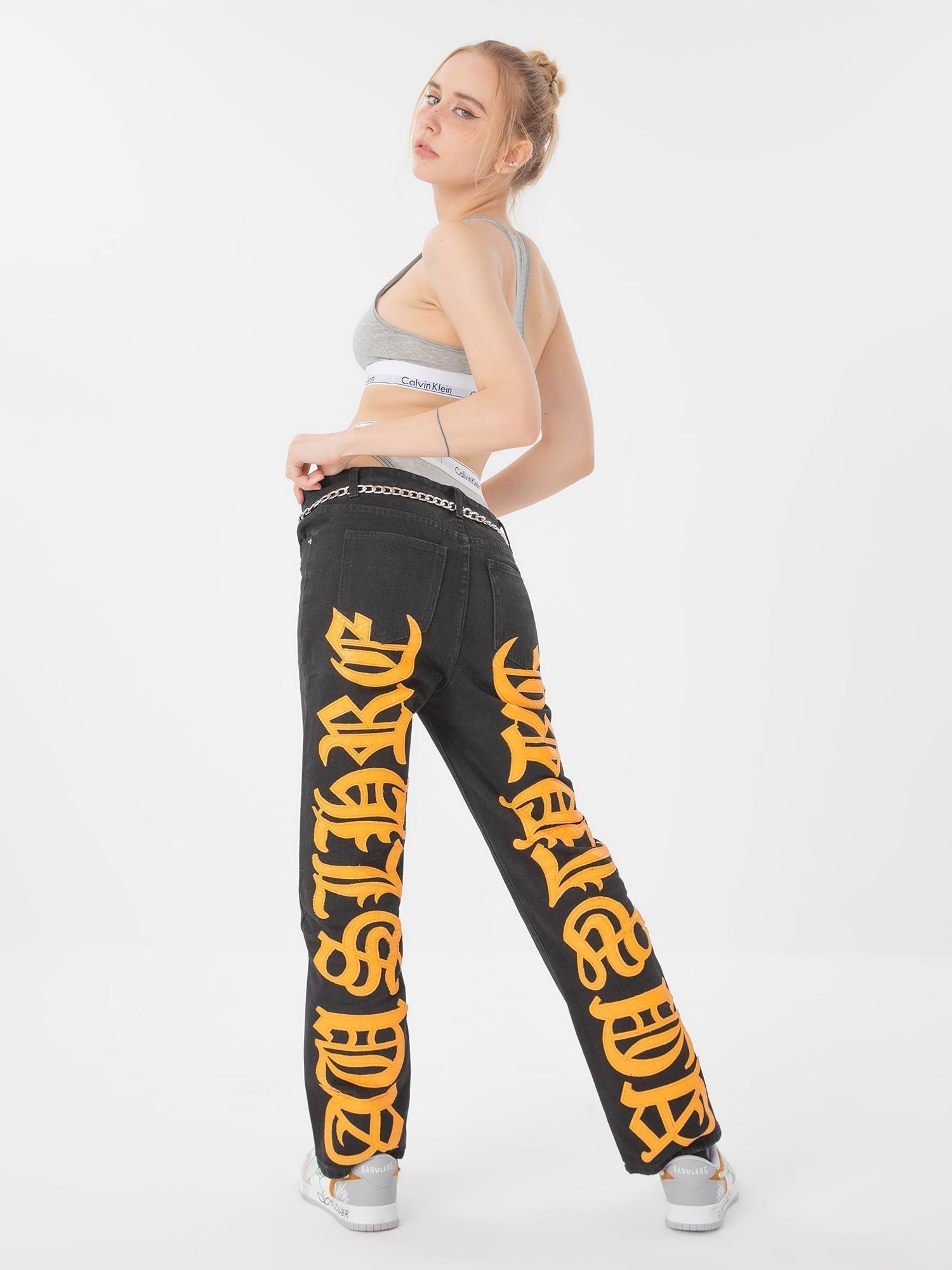 BLACK JEANS WITH ORANGE GOTHIC LETTERING FASHION STATEMENT APPAREL